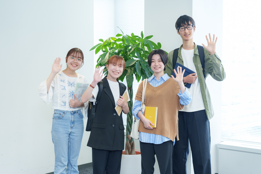 笑顔で手を振る大学生サポーターたち